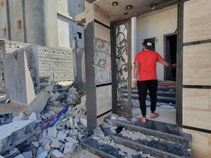 A libyan youth checks a damaged building entrance in the Salaheddin district south of the capital Tripoli, on June 21, 2020, as some residents return to the area after it has been demined. Since 2015, a power struggle has pitted the Tripoli-based Government of National Accord (GNA) against strongman Khalifa Haftar. (Mahmud TURKIA / AFP)