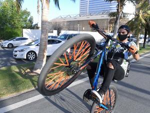 Saudi youths ride bicycles at the seafront promenade in the Saudi seaport of jeddah, on June 21, 2020, as the country re-opens following the lifting of a lockdown due to the COVID-19 pandemic. AMER HILABI / AFP