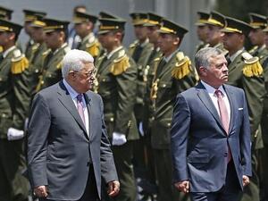 Jordan's King Abdullah II and Palestinian Authority President Mahmoud Abbas observe the honor guard during a visit in the West Bank city of Ramallah on August 7, 2017. (AFP PHOTO / ABBAS MOMANI)