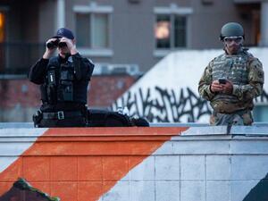 Personnel from the Seattle Police Department and the Washington National Guard keep an eye on demonstrators from a rooftop near the Seattle Police Departments East Precinct on June 6, 2020 in Seattle, Washington. This is the 12th day of protests since George Floyd died in Minneapolis police custody on May 25. David Ryder/Getty Images/AFP David Ryder / GETTY IMAGES NORTH AMERICA / Getty Images via AFP