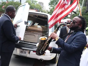 Taufeeq Wright plays a saxophone next to the hearse carrying the casket bearing the remains of Rayshard Brooks after his funeral service at the Ebenezer Baptist Church on June 23, 2020 in Atlanta, Georgia. Brooks was killed June 12 by an Atlanta police officer after a struggle during a field sobriety test in a Wendy's restaurant parking lot. Joe Raedle/Getty Images/AFP