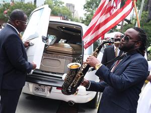 Taufeeq Wright plays a saxophone next to the hearse carrying the casket bearing the remains of Rayshard Brooks after his funeral service at the Ebenezer Baptist Church on June 23, 2020 in Atlanta, Georgia. Brooks was killed June 12 by an Atlanta police officer after a struggle during a field sobriety test in a Wendy's restaurant parking lot. Joe Raedle/Getty Images/AFP