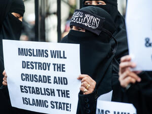 A woman holds a placard reading "Muslims will destroy the crusade and estabilish the Islamic State!" outside the Regents Park Mosque. (Shutterstock/ File Photo)