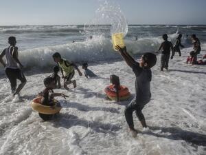 Palestinian children play in the waters of Rafah beach in the southern Gaza Strip on June 19, 2020. SAID KHATIB / AFP