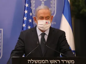 Israeli Prime Minister Benjamin Netanyahu wears a face mask against Covid-19, bearing the US and Israeli flags, during a press conference with US special representative for Iran at the prime minister's office in Jerusalem on June 30, 2020. ABIR SULTAN / POOL / AFP