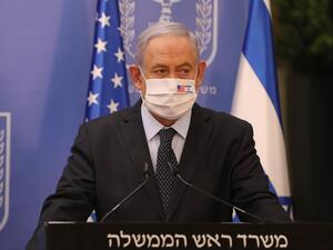 Israeli Prime Minister Benjamin Netanyahu wears a face mask against Covid-19, bearing the US and Israeli flags, during a press conference with US special representative for Iran at the prime minister's office in Jerusalem on June 30, 2020. ABIR SULTAN / POOL / AFP
