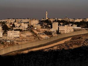 This picture taken on June 30, 2020 shows a view of Israel's controversial separation barrier between the West Bank city of Abu Dis (background) and East Jerusalem (foreground). AHMAD GHARABLI / AFP
