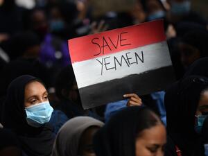 A protester holds a Yemeni flag-themed placard in Parliament Square in London on July 5, 2020, as she demonstrates against the continued conflict in Yemen. Yemen has been locked in conflict since the Huthis took control of Sanaa in 2014 and went on to seize much of the north. The crisis escalated when the Saudi-led coalition intervened the following year to support Yemen's internationally-recognised government. Tens of thousands of people, mostly civilians, have been killed and millions displaced in what th