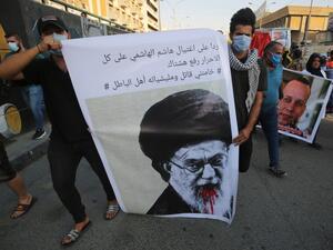 Iraqi demonstrators attend a symbolic funeral for slain Iraqi jihadism expert Hisham al-Hashemi, who was shot dead yesterday outside his house in the Iraqi capital, on July 7, 2020 at Baghdad's Tahrir square. Slogan reads in Arabic: "in response to the killing of Hashem al Hashemi, all free are to use the hashtag "Khamenei (Iran's Supreme Leader Ayatollah Ali Khamenei) is a killer and his militias are wrongdoers". (AHMAD AL-RUBAYE / AFP)