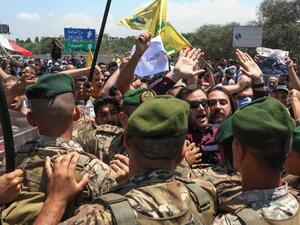 Lebanese soldiers block the road as supporters of Hezbollah and the Communist Party demonstrate at the entrance of Beirut's international airport on July 8, 2020, to denounce the visit of the US Central Command chief to the country. ANWAR AMRO / AFP