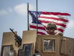 A US soldier sits atop a vehicle in a convoy patrolling an area in the countryside of Tal Tamr town, in Syria's northeastern Hasakeh province near the border with Turkey, on July 11, 2020. Delil SOULEIMAN / AFP