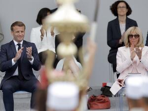 French President Emmanuel Macron (L) and his wife Brigitte Macron applaud during the annual Bastille Day military ceremony on the Place de la Concorde in Paris, on July 14, 2020. France holds a reduced version of its traditional Bastille Day parade this year due to safety measures over the COVID-19 (novel coronavirus) pandemic, and with the country's national day celebrations including a homage to health workers and others fighting the outbreak. Christophe Ena / POOL / AFP