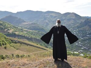 Priest Ter Abel prays for peace outside the village of Movses on the Armenian-Azerbaijani border on July 15, 2020. Defence officials in Armenia and Azerbaijan said fighting on their border subsided on July 15, 2020 after several days of deadly clashes raised fears of a major flare-up. At least 16 people on both sides were killed in three days of shelling that started Sunday between the ex-Soviet republics, which have been locked for decades in a conflict over Azerbaijan's separatist region of Nagorny Karaba