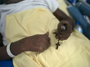 A COVID-19 patient holds a rosary at the post-COVID-19 ward of the Pedro Ernesto University Hospital (HUPE) in Rio de Janeiro, Brazil, on July 15, 2020, amid the novel coronavirus pandemic. The ward treats patients facing economic and social lacks that affect their capacity to keep proper medical care of their several health complications caused by COVID-19 and other diseases. Mauro PIMENTEL / AFP