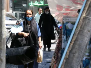 Mask-clad Iranians walk along a street in the capital Tehran, amid the ongoing novel coronavirus pandemic crisis, on July 19, 2020. Iran's president said yesterday that 35 million Iranians may contract the coronavirus, as the country still did not have herd immunity although a quarter of the population may have already been infected. The country has been battling a resurgence of COVID-19, with figures showing a rise in both new infections and deaths since a two-month low in May. ATTA KENARE / AFP