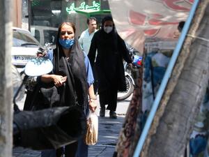 Mask-clad Iranians walk along a street in the capital Tehran, amid the ongoing novel coronavirus pandemic crisis, on July 19, 2020. Iran's president said yesterday that 35 million Iranians may contract the coronavirus, as the country still did not have herd immunity although a quarter of the population may have already been infected. The country has been battling a resurgence of COVID-19, with figures showing a rise in both new infections and deaths since a two-month low in May. ATTA KENARE / AFP