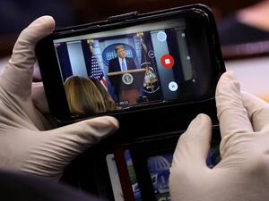 A journalist wears latex gloves to protect against the coronavirus while taking photos of U.S. President Donald Trump during a news conference about his administration's response to the ongoing pandemic in the Brady Press Briefing Room at the White House July 22, 2020 in Washington, DC. This is the second briefing the president has given in as many days. Poll numbers about his handling of COVID-19 have been falling as cases of deadly virus have spiked across the country. Chip Somodevilla/Getty Images/AFP CH