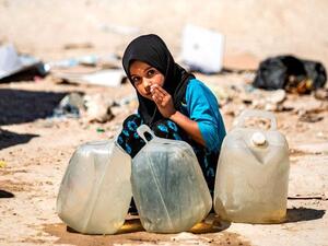 A displaced Syrian girl washes her mouth at Al Hol camp for the internally displaced people in Al Hasakeh governorate in northeastern Syria (AFP photo)