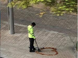 A photo of a Dubai cleaner crafting a heart out of some twigs, dried leaves he had collected while sweeping the street has gone viral on social media. (Twitter)