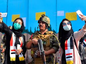 Iraqi students pose for selfies with a member of the security forces during ongoing anti-government protests in the central city of Diwaniyah on October 31, 2019.  (Haidar Hamdani / AFP / Getty)