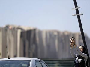 A woman takes a selfie near Beirut port on August 5, 2020 in the aftermath of a massive explosion in the Lebanese capital Beirut. Rescuers searched for survivors in Beirut after a cataclysmic explosion at the port sowed devastation across entire neighbourhoods, killing more than 100 people, wounding thousands and plunging Lebanon deeper into crisis. The blast, which appeared to have been caused by a fire igniting 2,750 tonnes of ammonium nitrate left unsecured in a warehouse, was felt as far away as Cyprus,