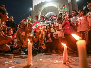 Palestinians attend a candle light vigil in Rafah in the southern Gaza Strip on August 5, 2020, in support of Lebanon a day after a blast in a warehouse in the port of the Lebanese capital sowed devastation across entire city neighbourhoods. SAID KHATIB / AFP
