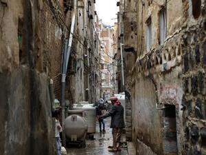 A Yemeni man stands in a flooded area following heavy rain fall on August 5, 2020 in the old city of the Yemeni capital Sanaa. The fierce storms have added to the woes of the war-torn country, which the UN has described as the world's worst humanitarian crisis. Five years of conflict has left swathes of the country in ruins. MOHAMMED HUWAIS / AFP