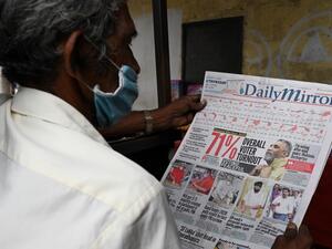 A man reads a newspaper with a headline on Sri Lanka's parliamentary polls 71% turnout, in Colombo on August 6, 2020.  LAKRUWAN WANNIARACHCHI / AFP