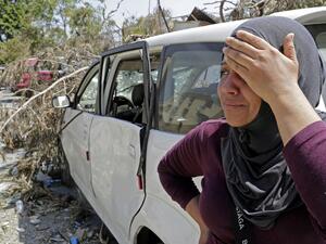 Rima Zahed stands near a damaged car at the entrance of the port of Beirut as she awaits for news of her missing brother Mohammed, a port employee, on August 8, 2020. More than 60 people are still missing in Beirut, four days after a massive explosion at the port left more than 150 people dead, a health ministry official said today. ANWAR AMRO / AFP