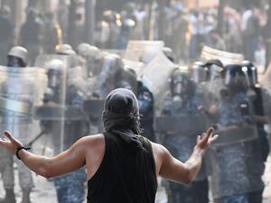 A Lebanese protester gestures towards security forces during clashes in downtown Beirut on August 8, 2020, following a demonstration against a political leadership they blame for a monster explosion that killed more than 150 people and disfigured the capital Beirut. AFP