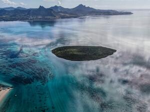 This aerial view taken on August 8, 2020 shows the Pointe d'Esny, and the Grand Port in the background, with a large patch of leaked oil and the vessel MV Wakashio, belonging to a Japanese company but Panamanian-flagged, that ran aground near Blue Bay Marine Park off the coast of south-east Mauritius. France on August 8, 2020 dispatched aircraft and technical advisers from Reunion to Mauritius after the prime minister appealed for urgent assistance to contain a worsening oil spill polluting the island natio