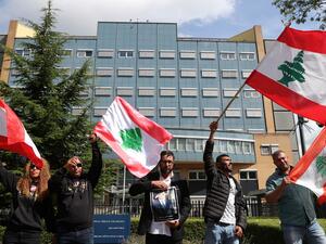 People gather and wave Lebanon national flags in front of the UN-backed Special Tribunal for Lebanon (STL) at Leidschendam on August 18, 2020, before the expected verdict on the 2005 murder of his father former Lebanese premier Rafic Hariri. (AFP/ File)