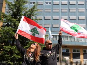 People gather and wave Lebanon national flags in front of the UN-backed Special Tribunal for Lebanon (STL) at Leidschendam on August 18, 2020, before the expected verdict on the 2005 murder of his father former Lebanese premier Rafic Hariri. KENZO TRIBOUILLARD / AFP