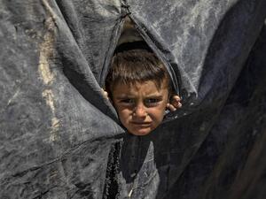 A boy looks out from a tent at the Kurdish-run al-Hol camp in the al-Hasakeh governorate in northeastern Syria on August 18, 2020, where families of Islamic State (IS) foreign fighters are held. Delil SOULEIMAN / AFP