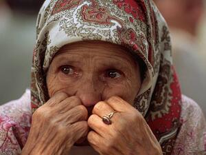 A woman arriving from Srebrenica sits quietly in front of a refugee shelter (Twitter)