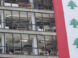 A Lebanese woman checks her phone as she sits in a devastated building in Beirut, on August 25, 2020, in the aftermath of a monster explosion at the port of Lebanon's capital which ravaged the city in early August. ANWAR AMRO / AFP