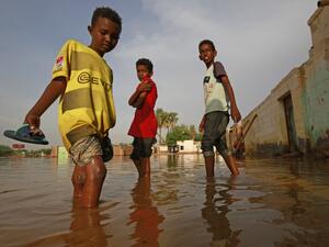 Sudanese boys make their way through a flooded street at the area of al-Qamayir in the capital's twin city of Omdurman, on August 26, 2020. Sudan on September 5 declared the imposition of a three-month state of emergency nationwide after record-breaking torrential floods caused by more than a month heavy rains left dozens dead and 100,000 damaged properties in their wake, in one of the worst natural disasters in decades, according to state news agency SUNA. ASHRAF SHAZLY / AFP
