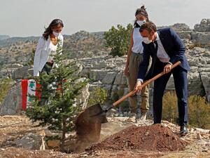 French President Emmanuel Macron (R) plants a cedar tree alongside members of the NGO Jouzour Loubnan during a ceremony marking Lebanon's centenary in Jaj Cedars Reserve Forest, northeast of the capital Beirut, on September 1, 2020. GONZALO FUENTES / POOL / AFP