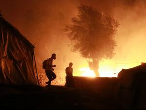 Migrants walk inside the Moria camp on the island of Lesbos during a major fire there on September 9, 2020. Manolis LAGOUTARIS / AFP