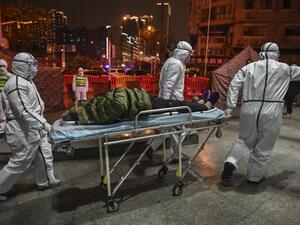 In this file photograph taken on January 25, 2020, medical staff members wearing protective clothing to help stop the spread of a deadly virus which began in the city, arrive with a patient at the Wuhan Red Cross Hospital in Wuhan. Hector RETAMAL / AFP