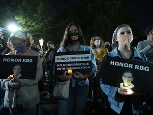 People holds signs and candles as they pay their respects to Ruth Bader Ginsburg near the US Supreme Court in Washington, DC on September 19, 2020. US President Donald Trump vowed to quickly nominate a successor, likely a woman, to replace late Supreme Court Justice Ruth Bader Ginsburg, only a day after the death of the liberal stalwart. Jose Luis Magana / AFP