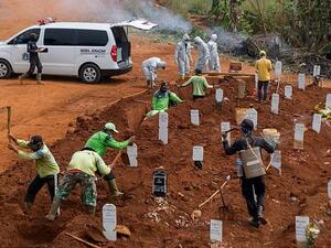 Workers dig holes at a burial site for victims of the Covid-19 coronavirus in Jakarta on September 11 (AFP)