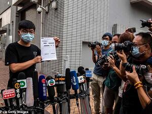 Pro-democracy activist Joshua Wong speaks to the media while holding up a bail document after leaving Central police station in Hong Kong on September 24, 2020. (AFP/File Photo)