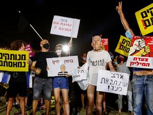 Israeli protesters wave national flags and chant slogans against the government near the prime minister's residence in Jerusalem. (AFP)