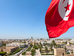 Top view of streets at Monastir city, Tunisia Minaret of mosque and Ribat as a fortress Red Tunisian flag  (Shutterstock)	