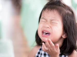 The Chinese girl is seen making a sour face while holding her tongue with her hand, seemingly overwhelmed by how spicy the chilli was. (Shutterstock)