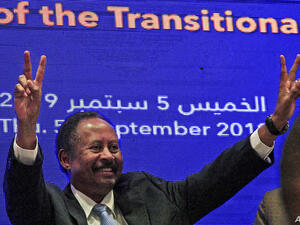 Sudanese Prime Minister Abdalla Hamdok flashes the victory gesture during a press conference unveiling the first Cabinet since veteran leader Omar al-Bashir's overthrow, in Khartoum, Sept. 5, 2019. (AFP)