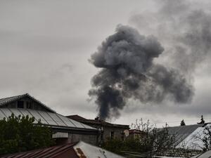 Smoke rises behind houses after shelling in the breakaway Nagorno-Karabakh region's main city of Stepanakert on October 7, 2020, during the ongoing fighting between Armenia and Azerbaijan over the disputed region. ARIS MESSINIS / AFP