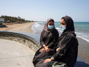 Omanis, wearing protective face masks, sit on the corniche in the capital Muscat on October 12, 2020, during the coronavirus pandemic. MOHAMMED MAHJOUB / AFP