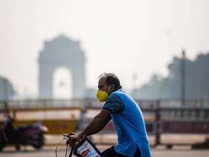 A man rides on a bicycle past India Gate amid smoggy condition in New Delhi on October 13, 2020. Jewel SAMAD / AFP